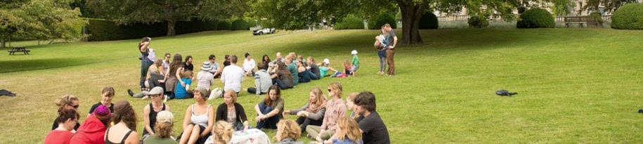 Groups of people sitting in groups on the greens of Royal Roads University