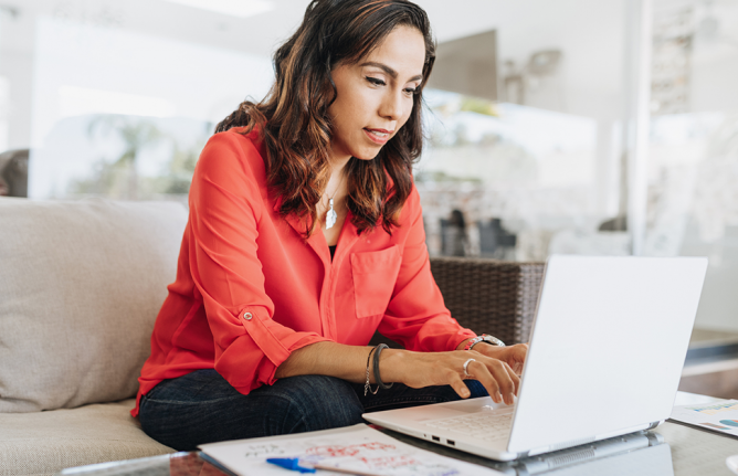 Person sitting on couch typing on computer