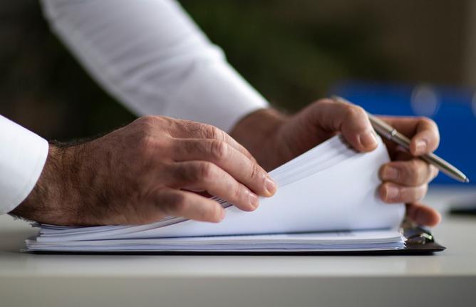 picture of a person's hand looking a papers