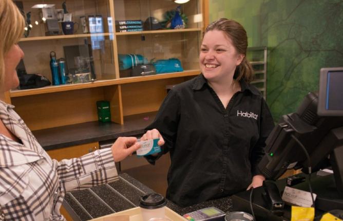 person handing cashier at cafeteria card