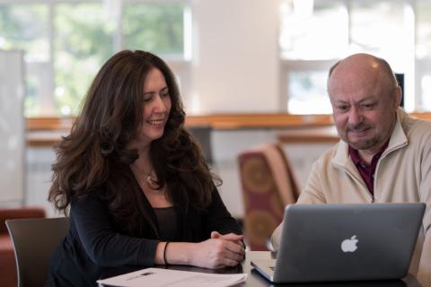 Two-people-looking-together-at-a-laptop