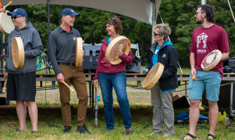 Group of people holding Indigenous drums