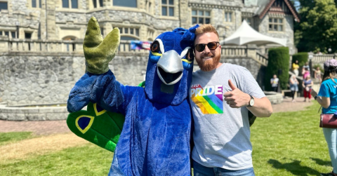 Peacock Mascot with Chris Ryan giving thumbs up