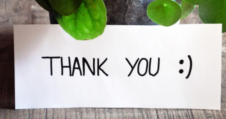 Thank you note leaning up against plant