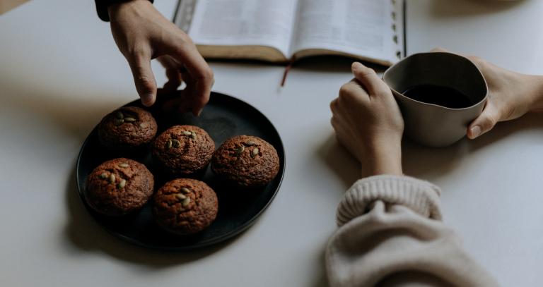 Overhead view of book and plate of muffins.